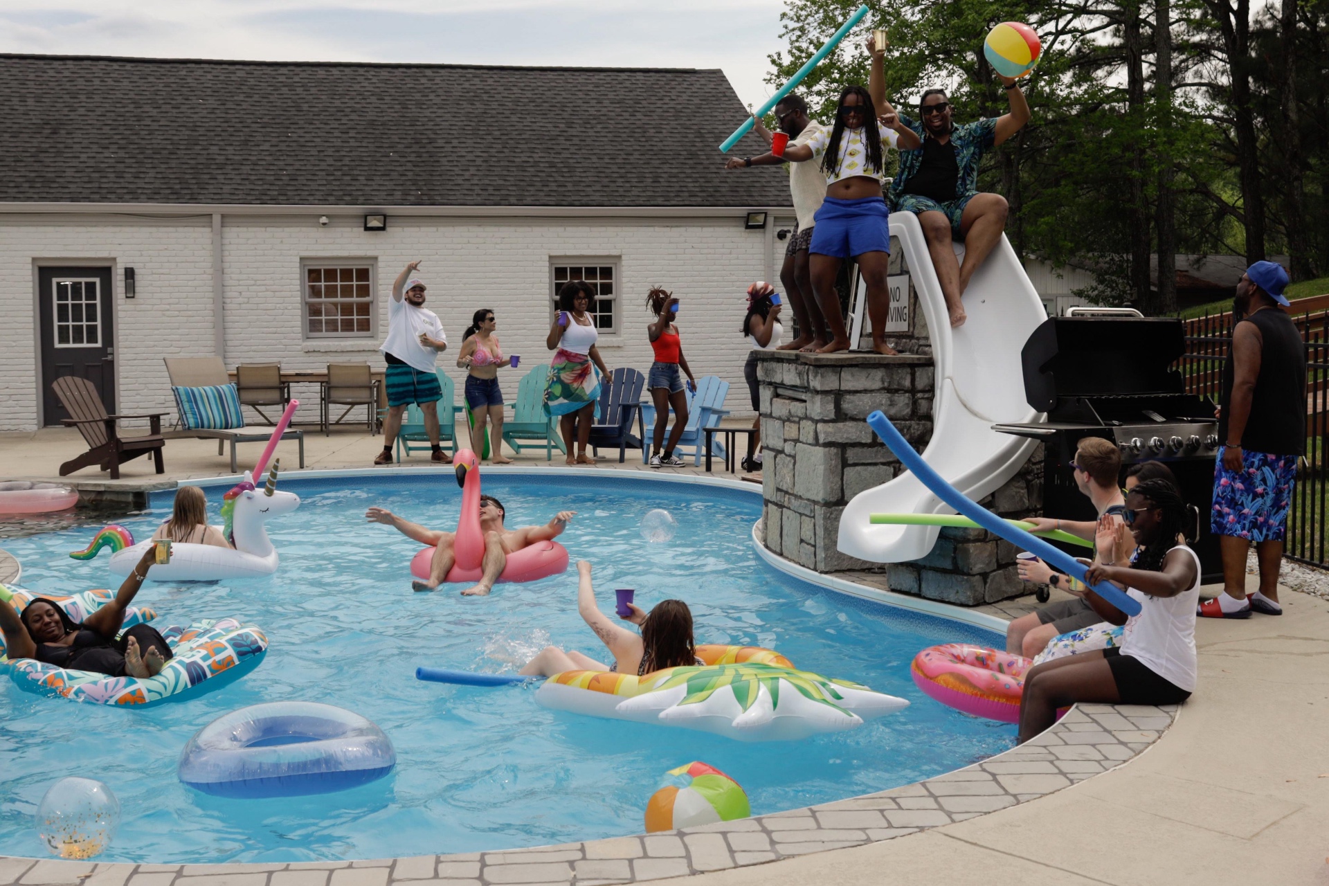 Pool party with floats, noodles, and a beach ball