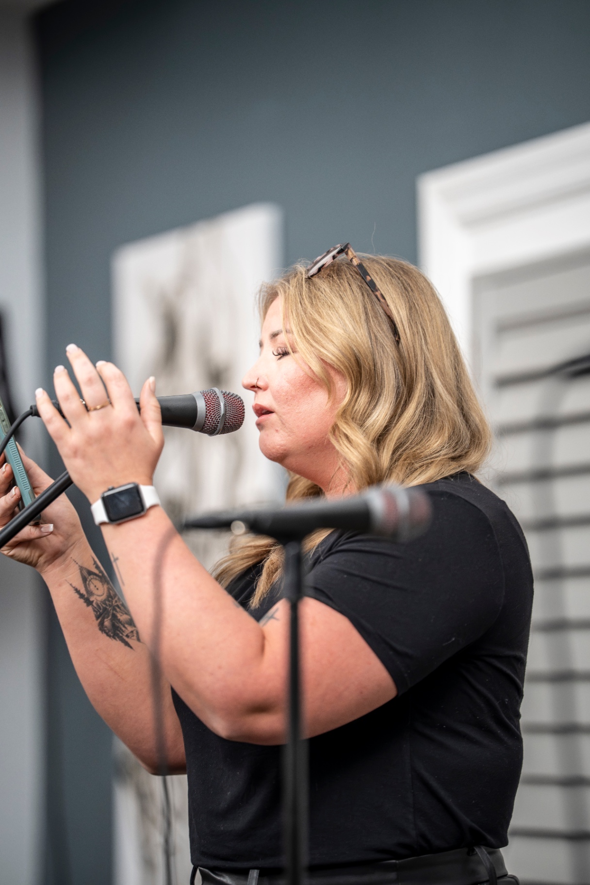 Performer in black reading lyrics into a microphone during the showcase
