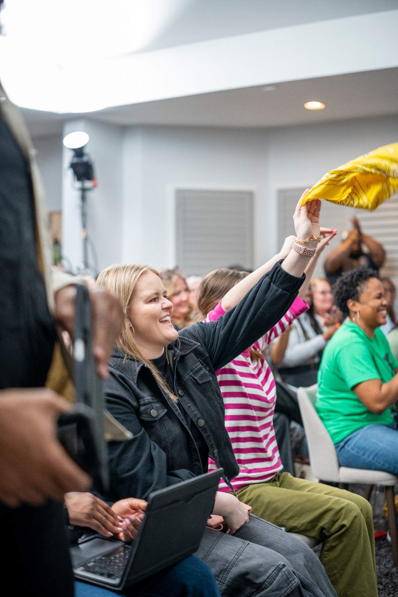 Audience member smiling and waving a yellow cloth during a live moment