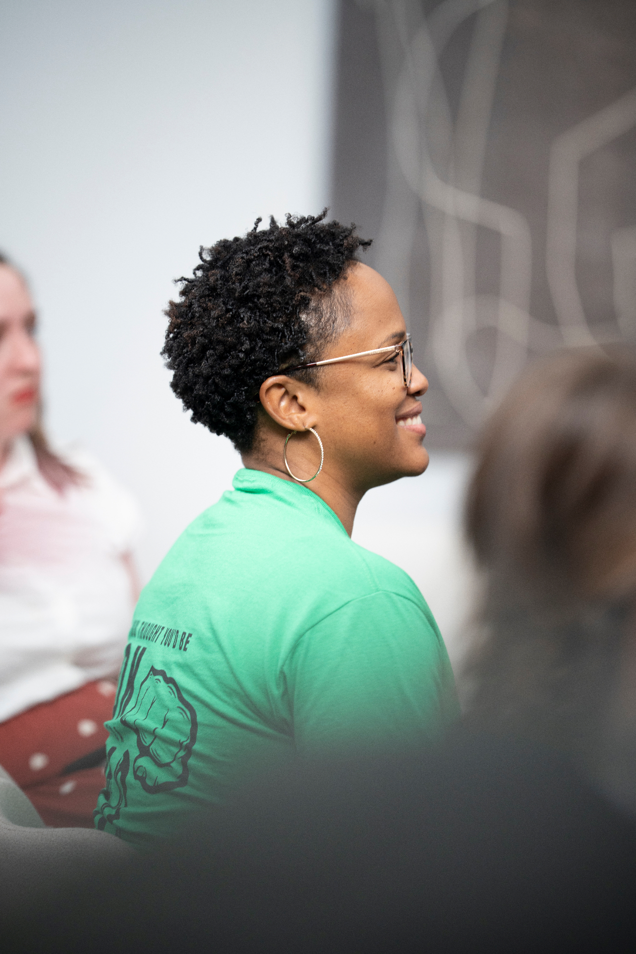 Audience member in a green shirt smiling during the event