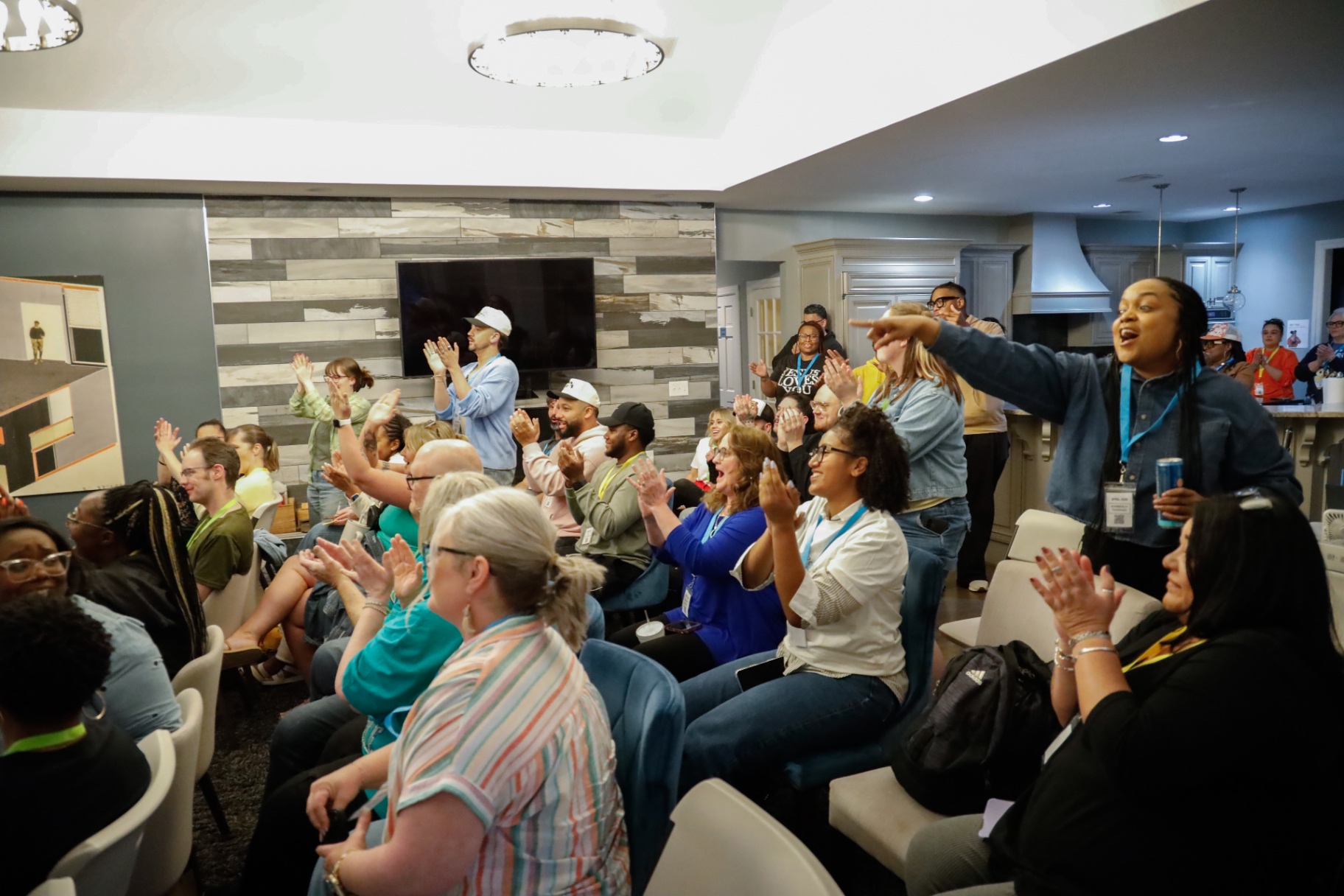 Packed living room of attendees clapping and cheering during a showcase