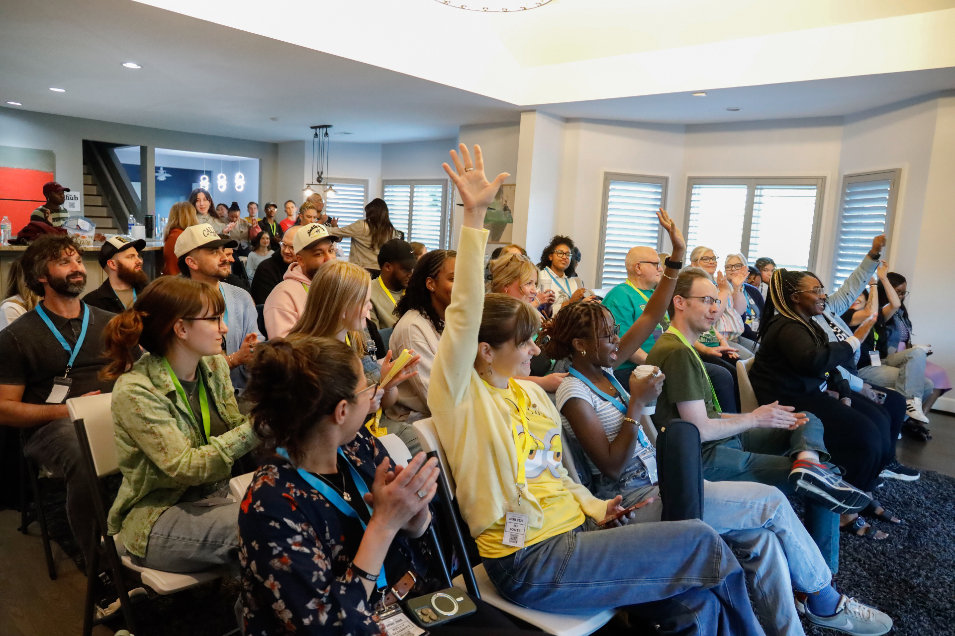 An engaged audience with hands raised during a session