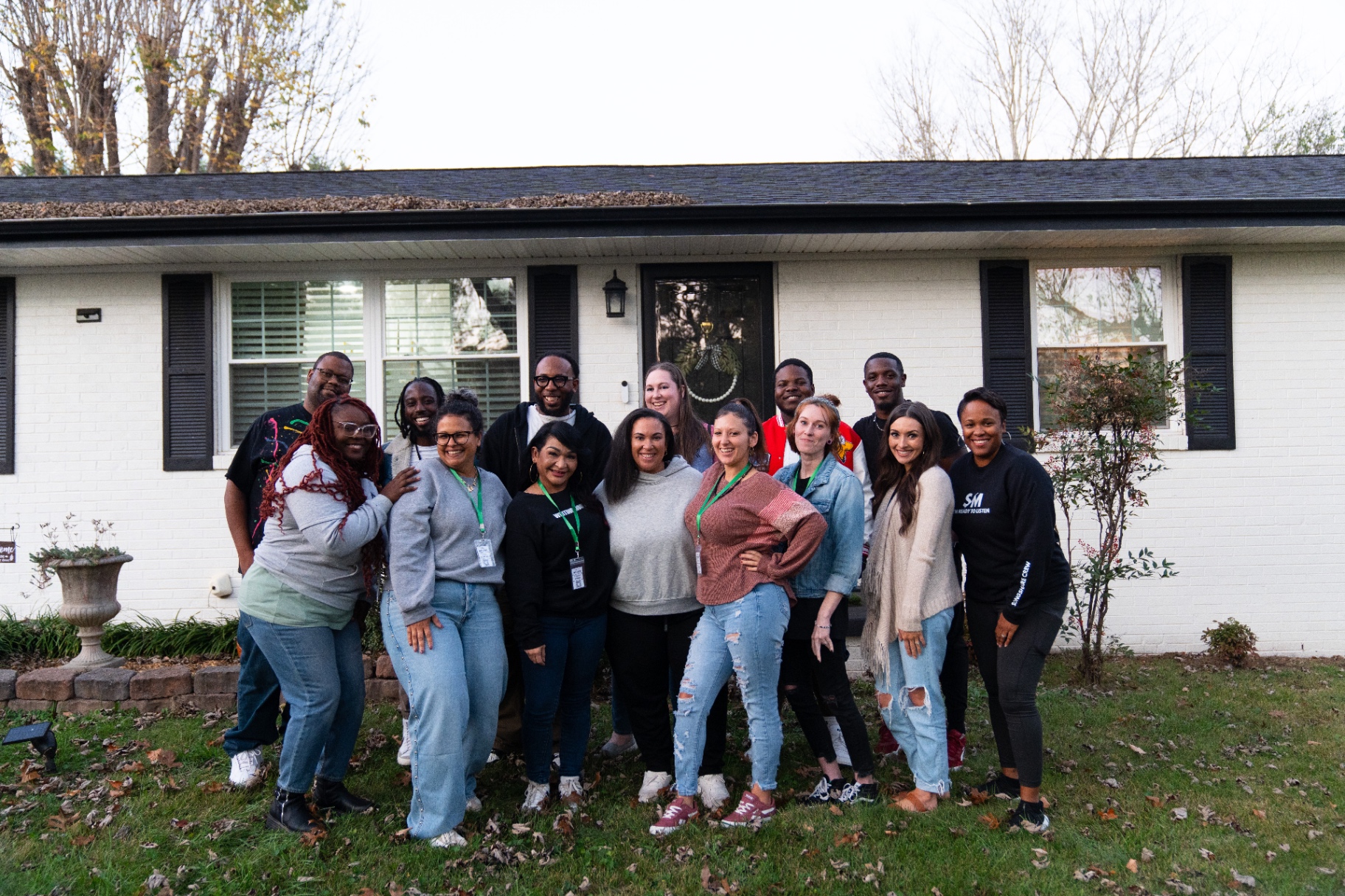 Group of writers smiling together in front of the writers house