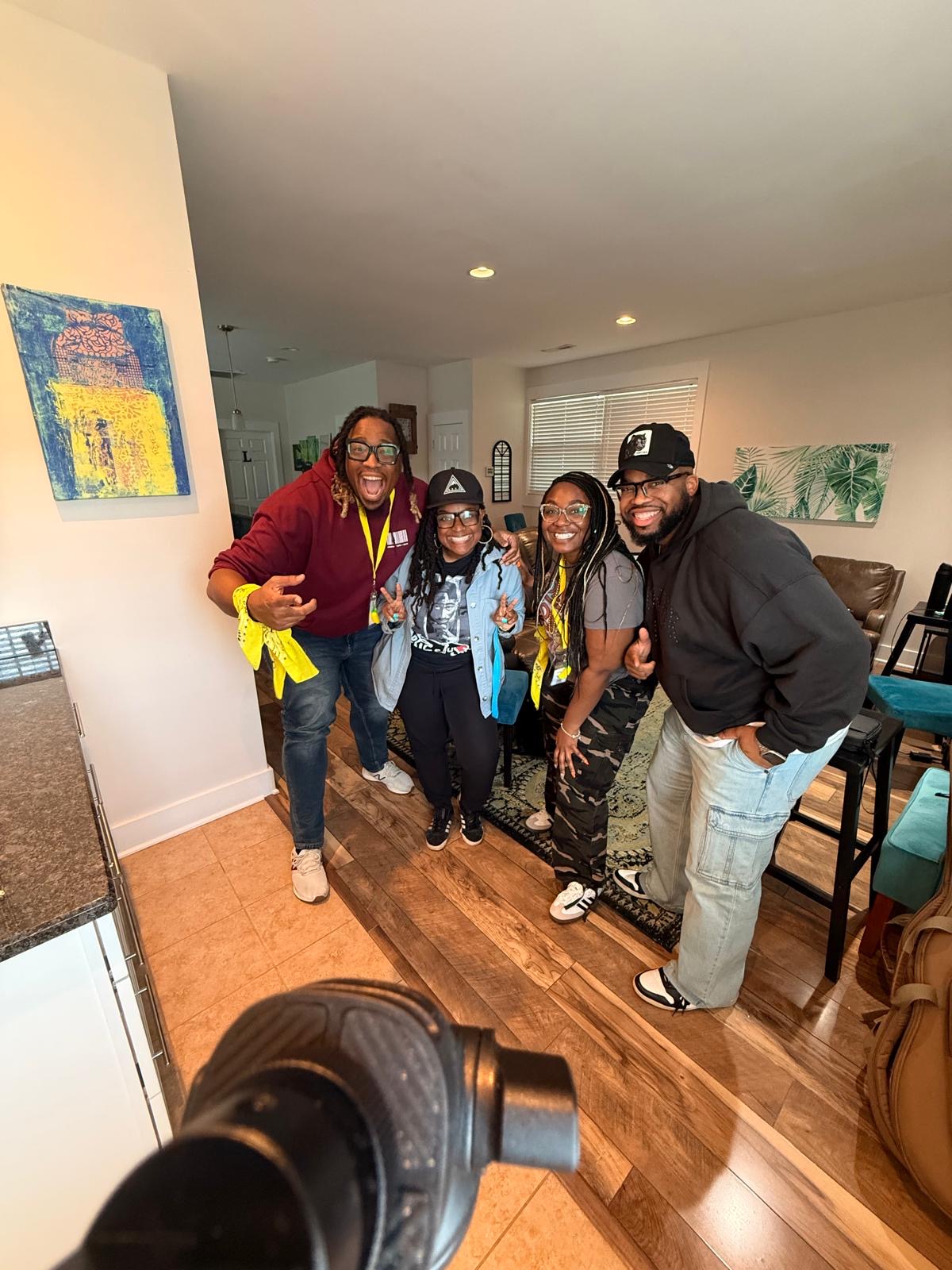 Four attendees posing playfully with yellow bandanas