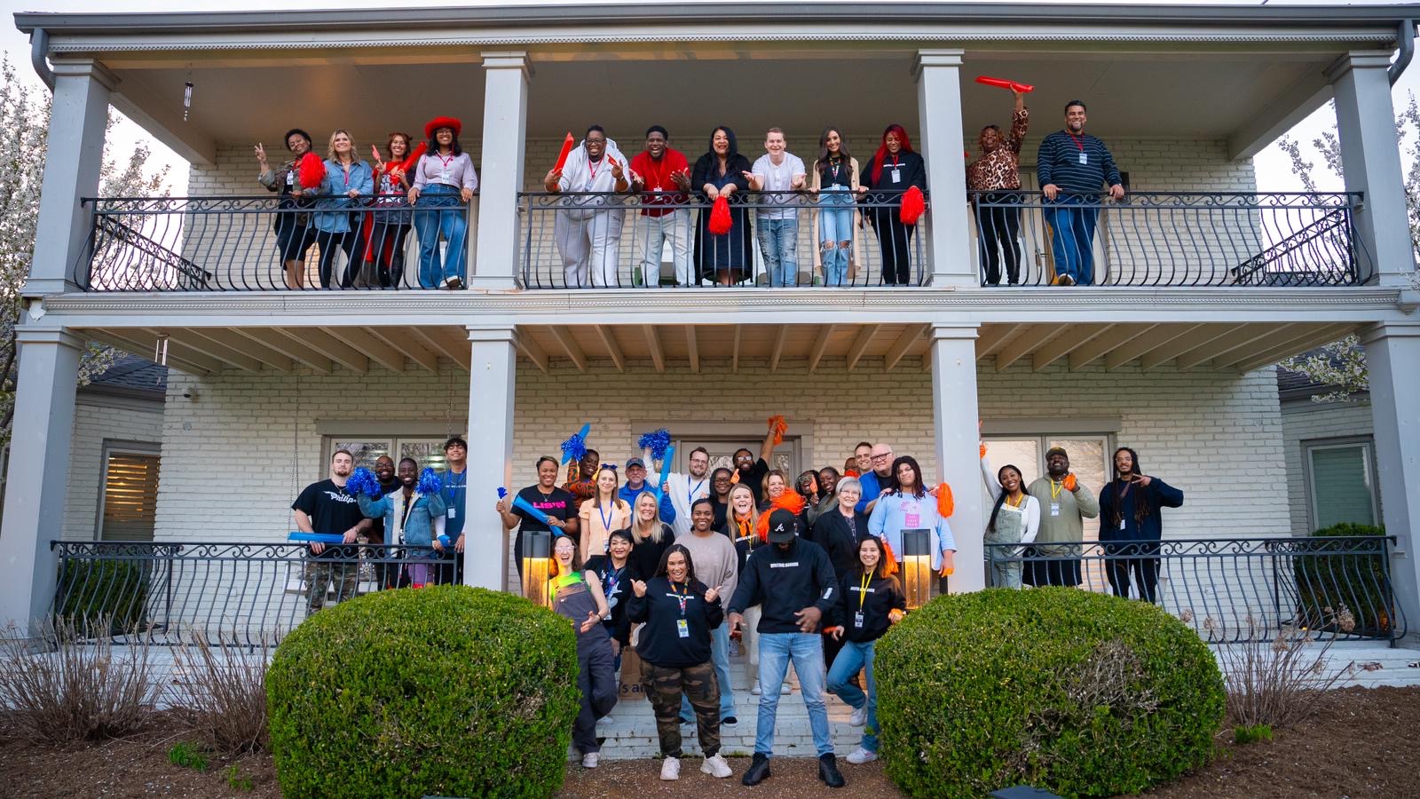 SongShare attendees gathered on the writers house porch with orange and blue pompoms