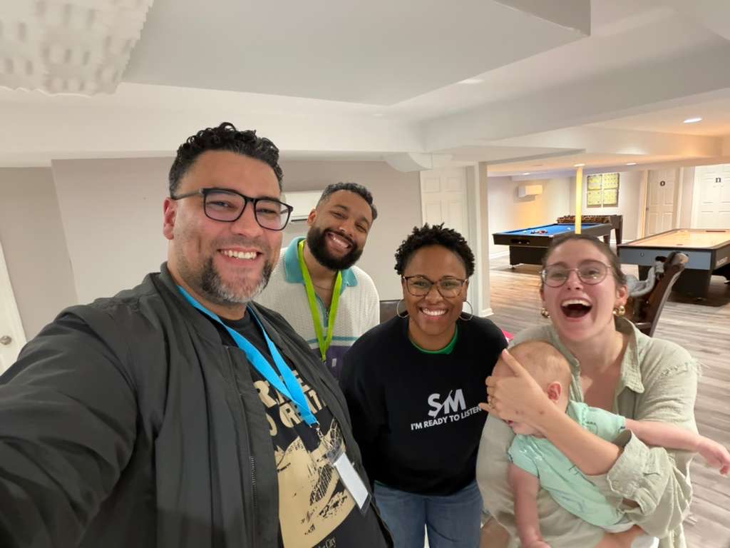 Selfie of friends with a baby at the eXperience